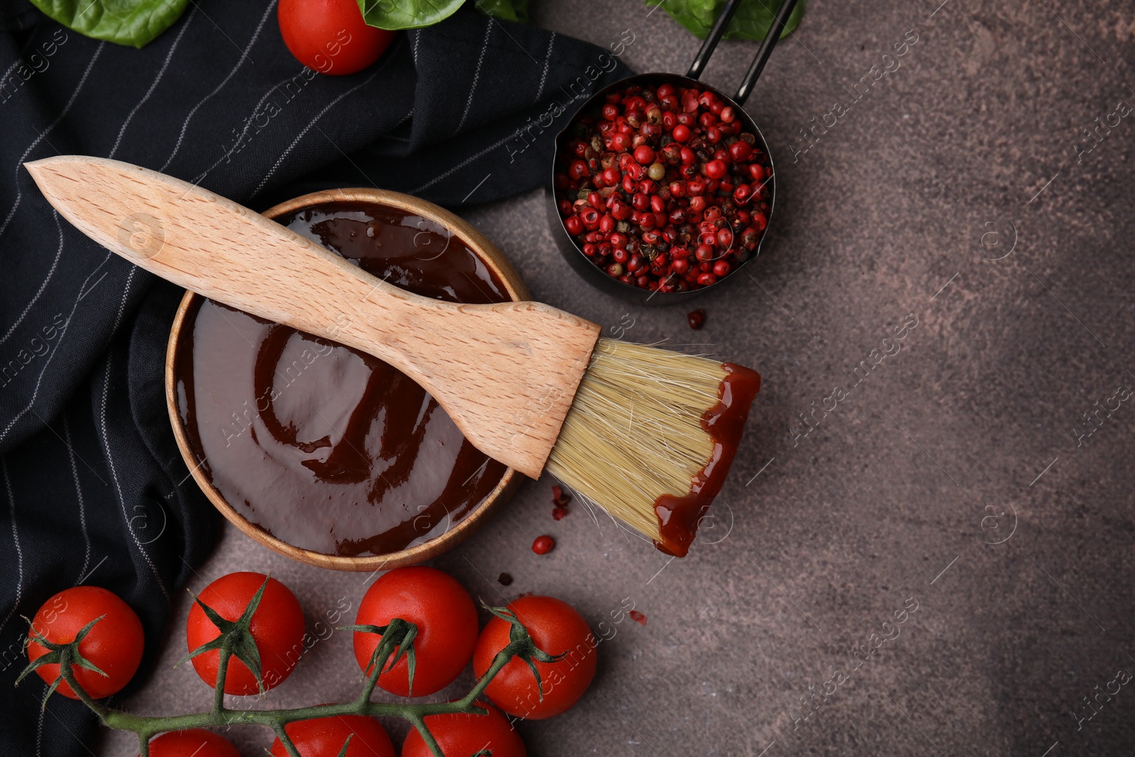 Photo of Flat lay composition with marinade in bowl and basting brush on brown table. Space for text