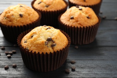 Delicious freshly baked muffins with chocolate chips on dark gray table, closeup