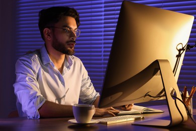 Photo of Tired young man working late in office