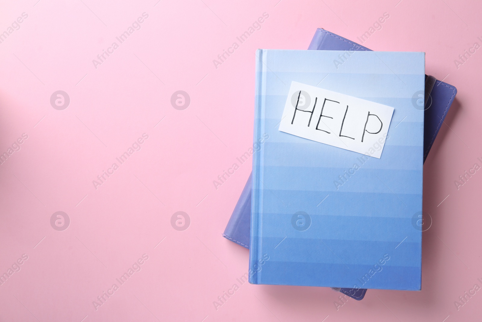 Photo of Notebooks and card with word HELP on color background, top view. Space for text