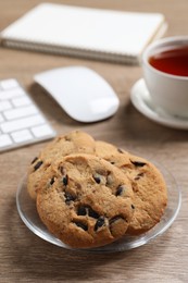 Chocolate chip cookies on wooden table at workplace