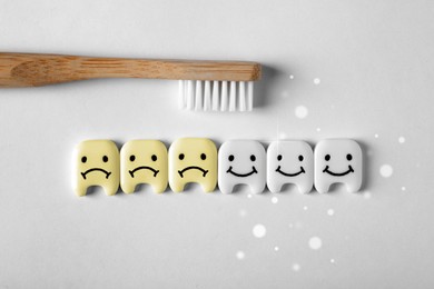 Small plastic teeth with faces and wooden brush on white background, flat lay. Whitening concept