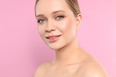 Portrait of young woman with beautiful face on pink background, closeup