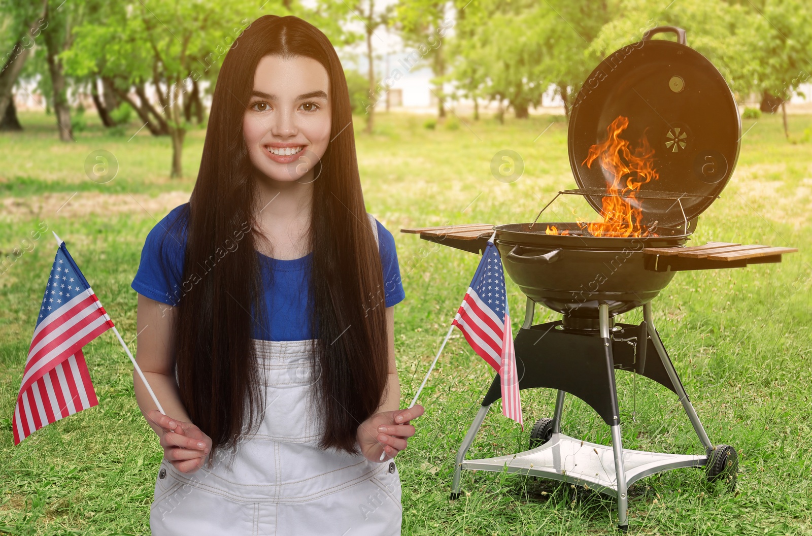 Image of 4th of July - Independence day of America. Happy girl with national flag of United States having picnic in park