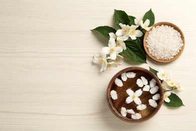 Flat lay composition with beautiful jasmine flowers, sea salt on white wooden table, space for text