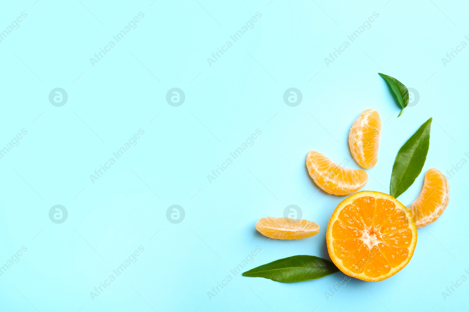 Photo of Composition with tangerine and leaves on color background, flat lay. Space for text