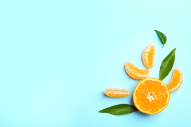 Photo of Composition with tangerine and leaves on color background, flat lay. Space for text