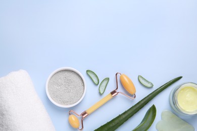 Photo of Flat lay composition with cosmetic products and cut aloe leaves on light blue background. Space for text