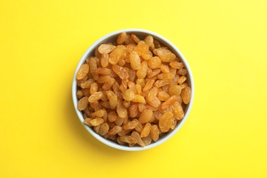 Photo of Bowl with raisins on color background, top view. Dried fruit as healthy snack