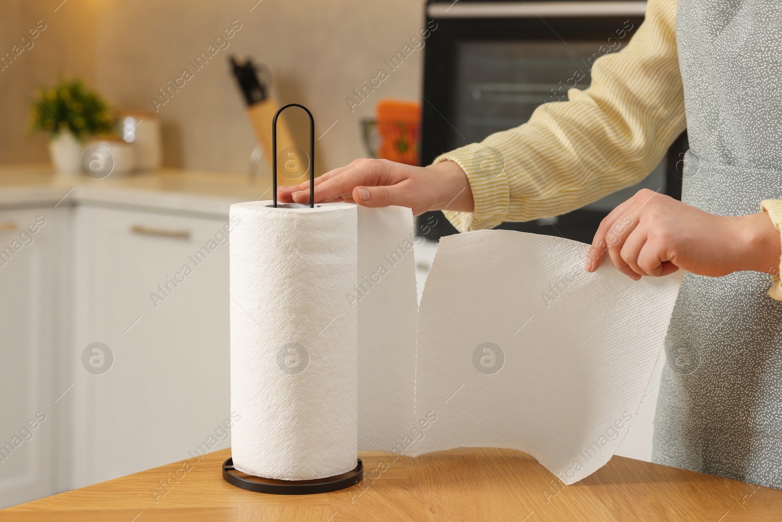 Photo of Woman using paper towels in kitchen, closeup