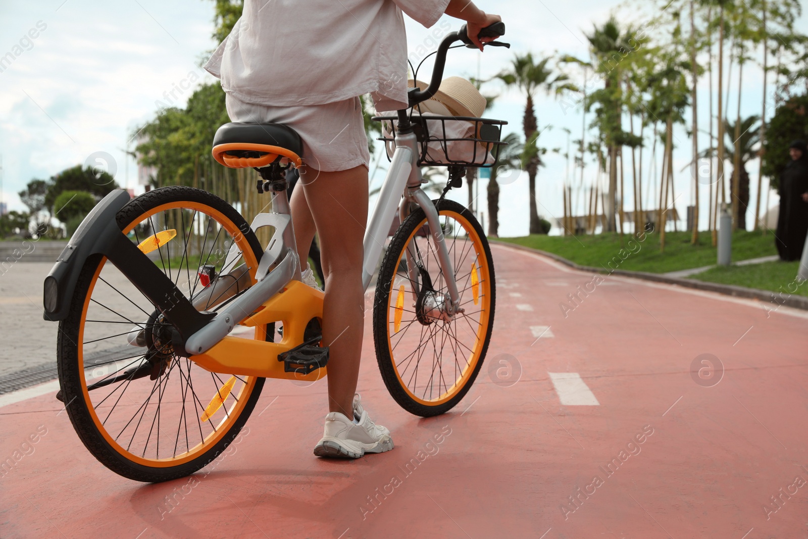 Photo of Young woman with bicycle on lane outdoors, closeup. Space for text