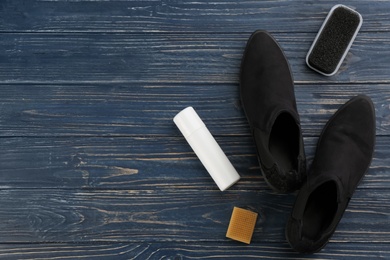 Stylish footwear with shoe care accessories on blue wooden table, flat lay. Space for text