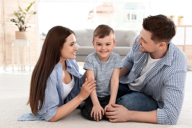 Happy couple with their son spending time together at home. Family weekend