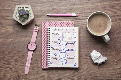 Image of Self organization with bullet journal. Notebooks, wristwatch and cup with coffee on wooden table, flat lay