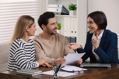 Professional notary working with couple in office