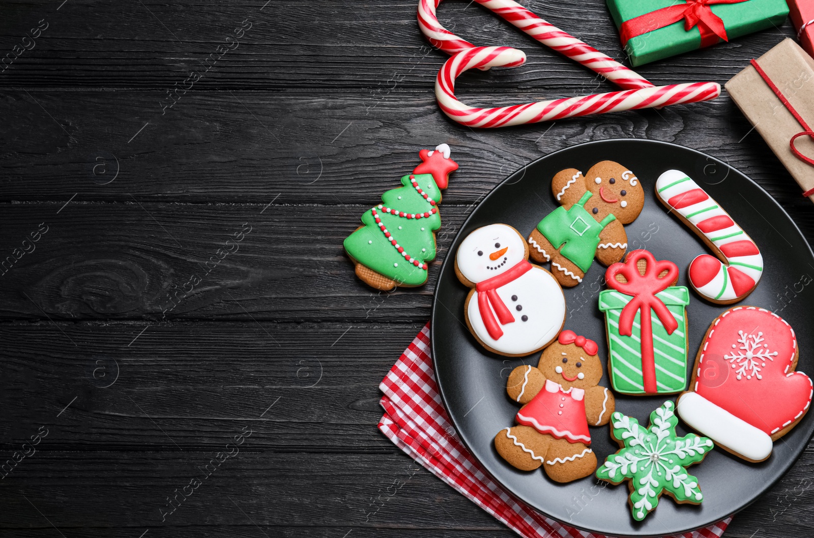 Photo of Delicious Christmas cookies on black wooden table table, flat lay. Space for text