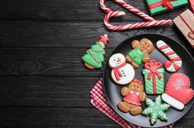 Photo of Delicious Christmas cookies on black wooden table table, flat lay. Space for text