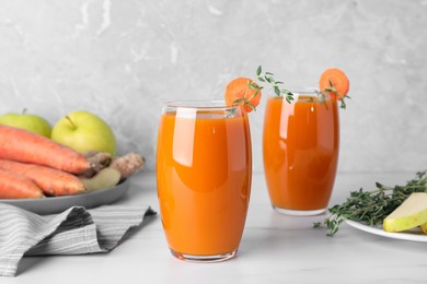 Photo of Glasses with healthy carrot juice on white table