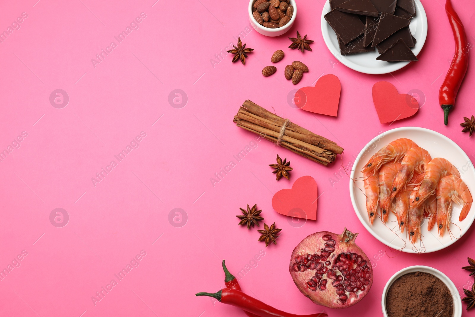 Photo of Natural aphrodisiac. Different products and paper hearts on pink background, flat lay. Space for text