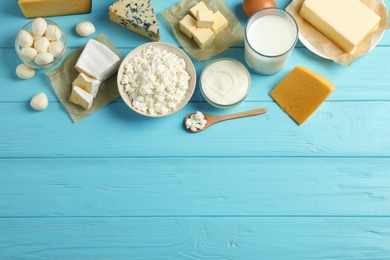 Different dairy products on blue wooden table, flat lay. Space for text