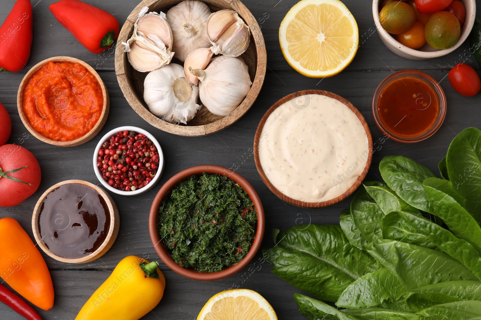 Photo of Different fresh marinades in bowls and ingredients on grey wooden table, flat lay