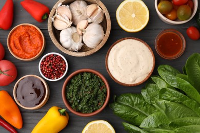 Photo of Different fresh marinades in bowls and ingredients on grey wooden table, flat lay