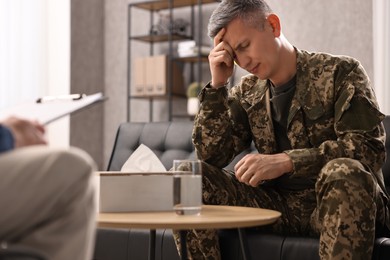 Photo of Professional psychotherapist working with military man in office