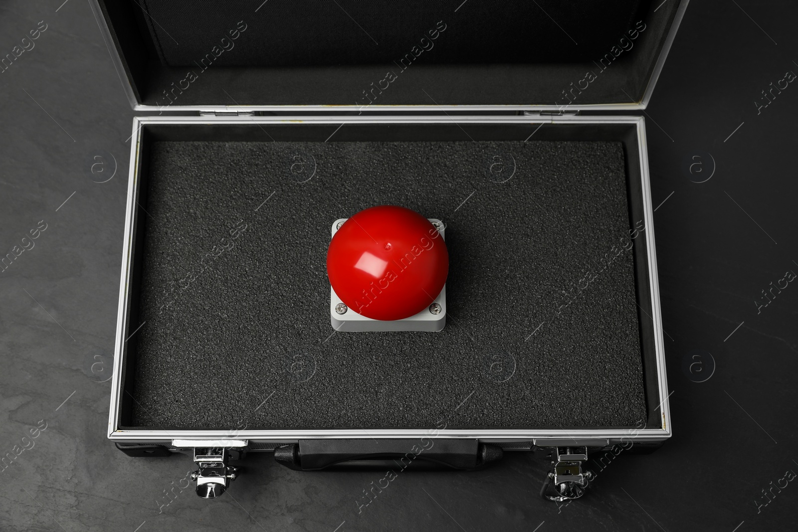 Photo of Red button of nuclear weapon in suitcase on black background, above view. War concept