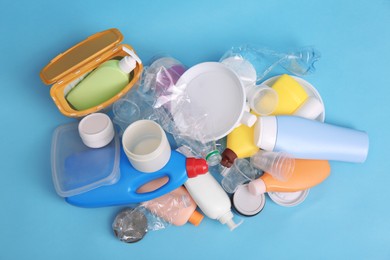 Photo of Pile of plastic garbage on light blue background, flat lay