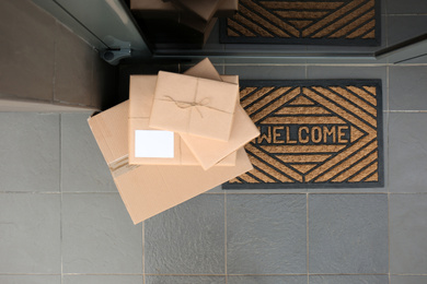 Photo of Cardboard boxes near door, top view. Parcel delivery service