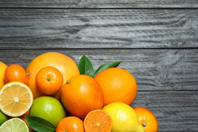 Photo of Flat lay composition with different citrus fruits and space for text on wooden background