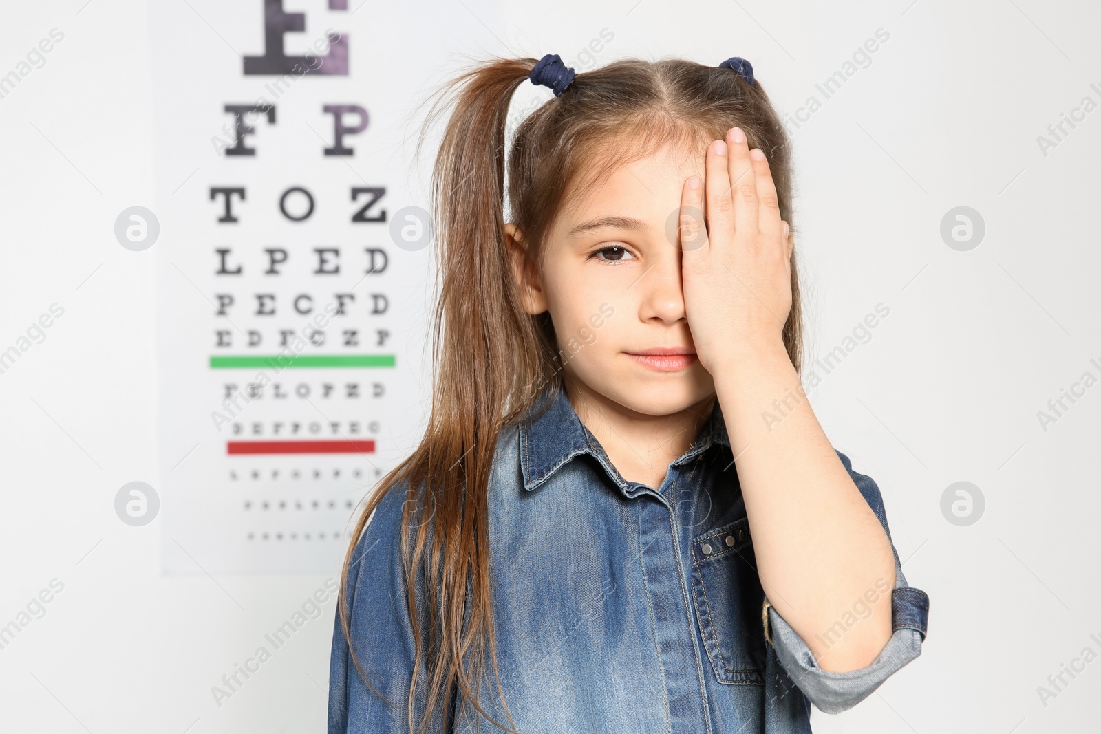 Photo of Cute little girl visiting ophthalmologist