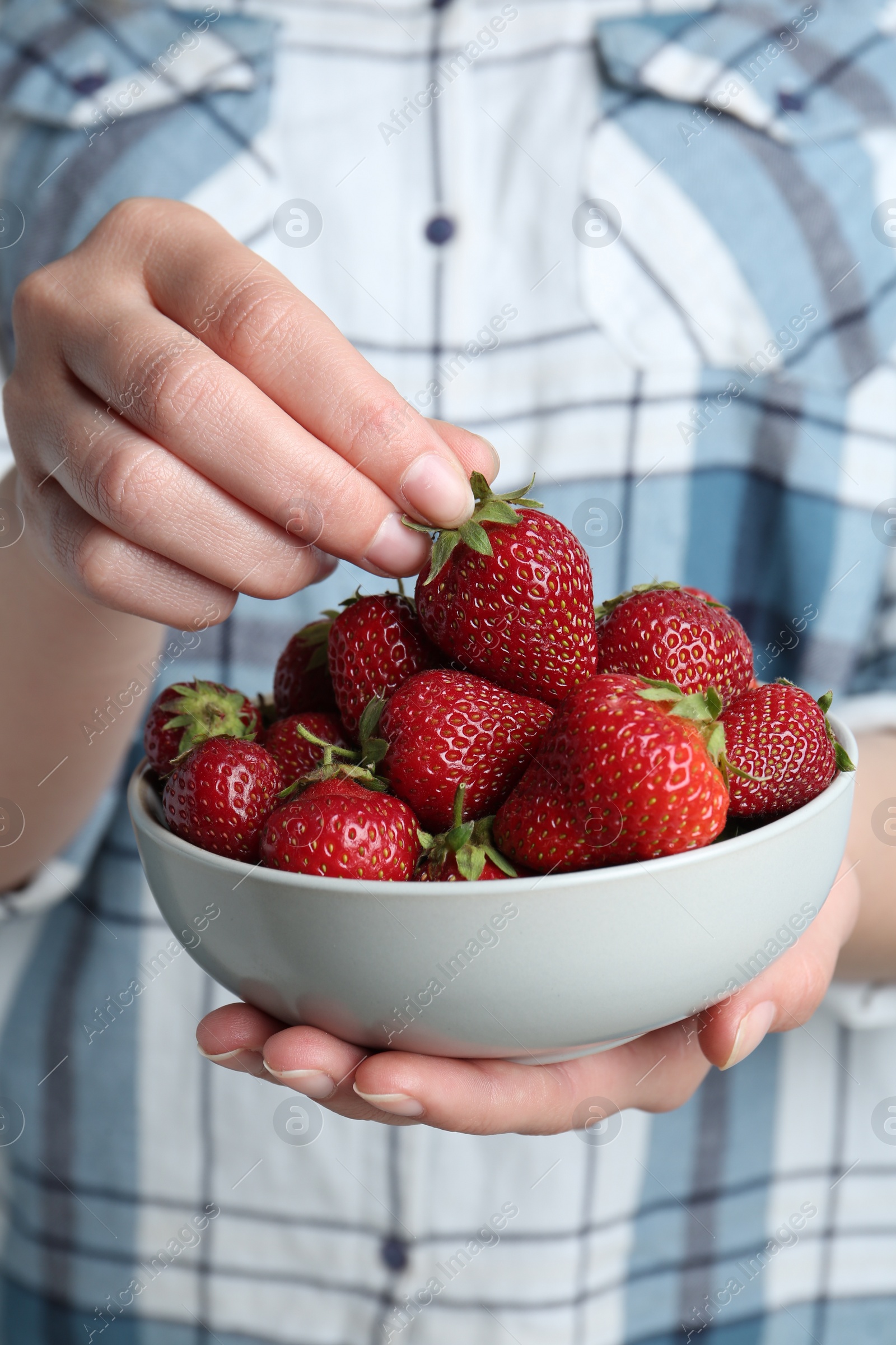 Photo of Woman holding bowl with tasty fresh strawberries, closeup