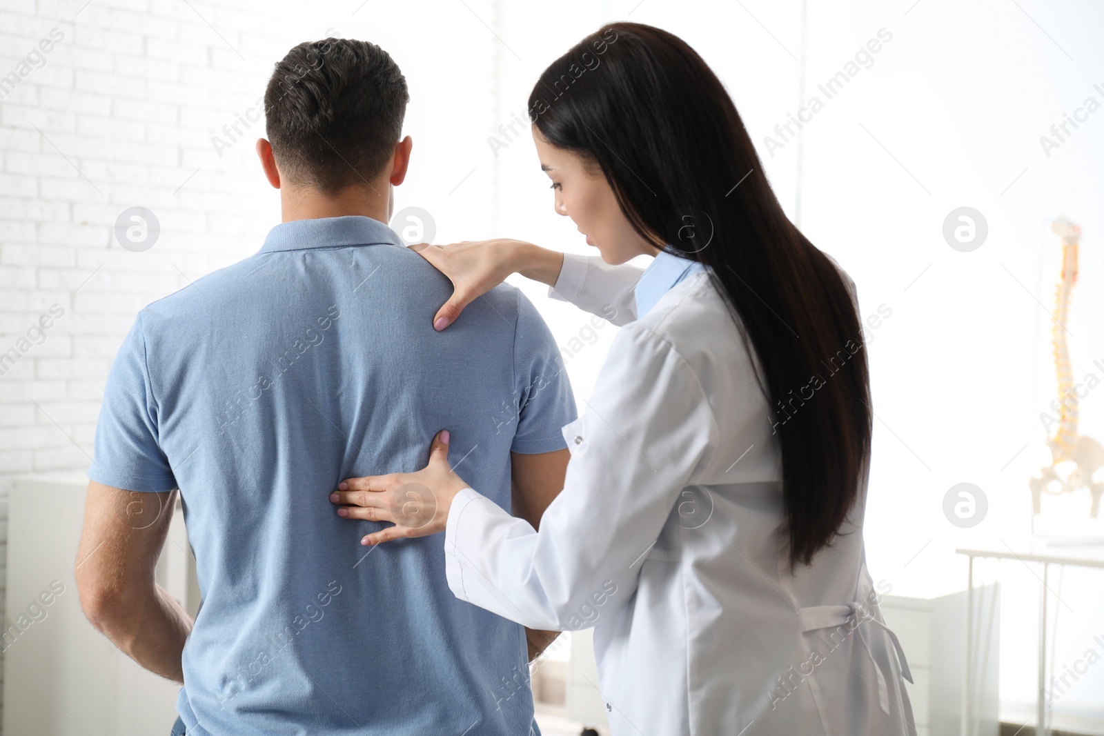 Photo of Professional orthopedist examining man in medical office