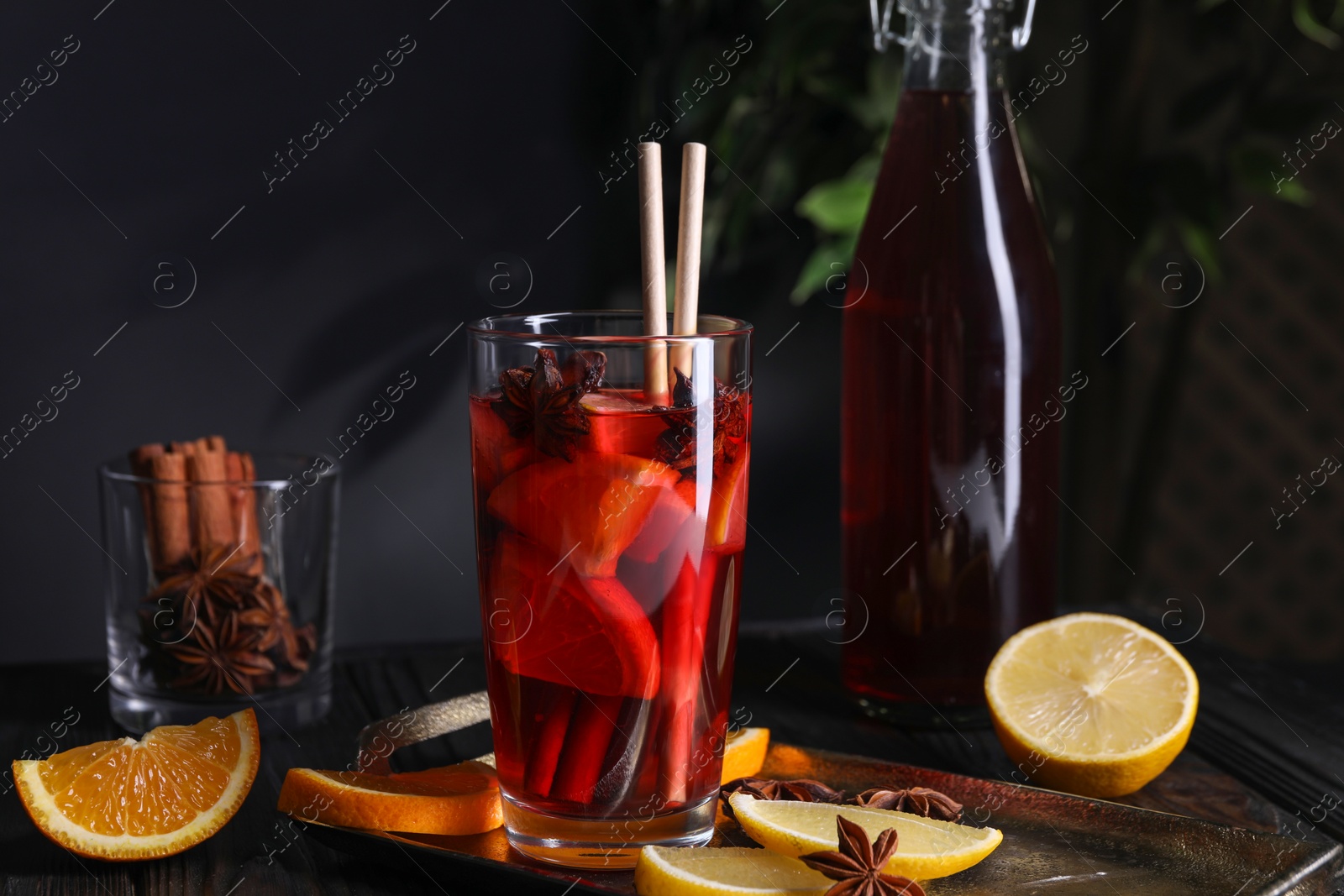 Photo of Glass of aromatic punch drink and ingredients on table