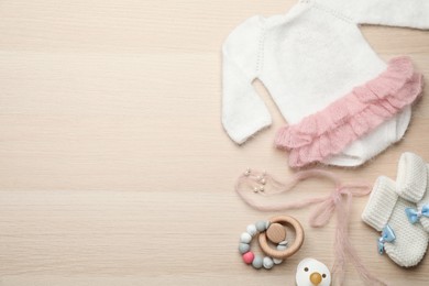 Photo of Cute baby stuff on wooden background, flat lay. Space for text