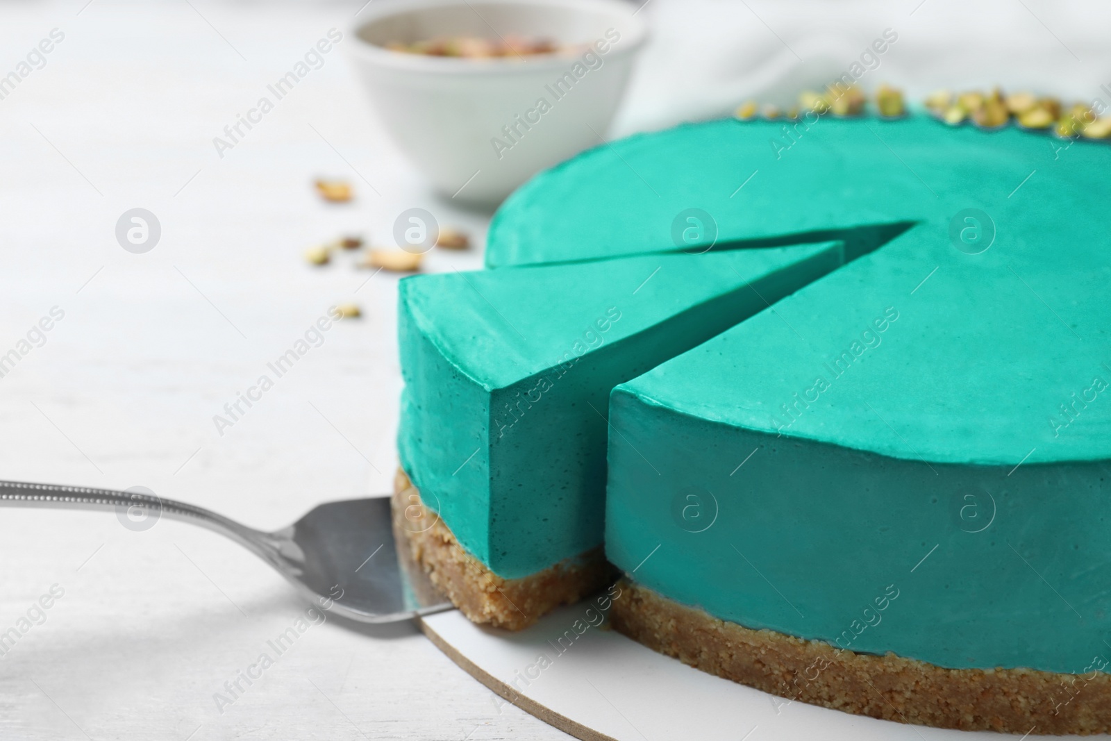 Photo of Delicious homemade spirulina cheesecake on white wooden background