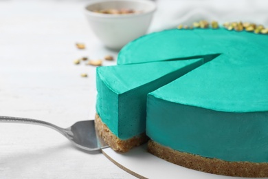 Photo of Delicious homemade spirulina cheesecake on white wooden background