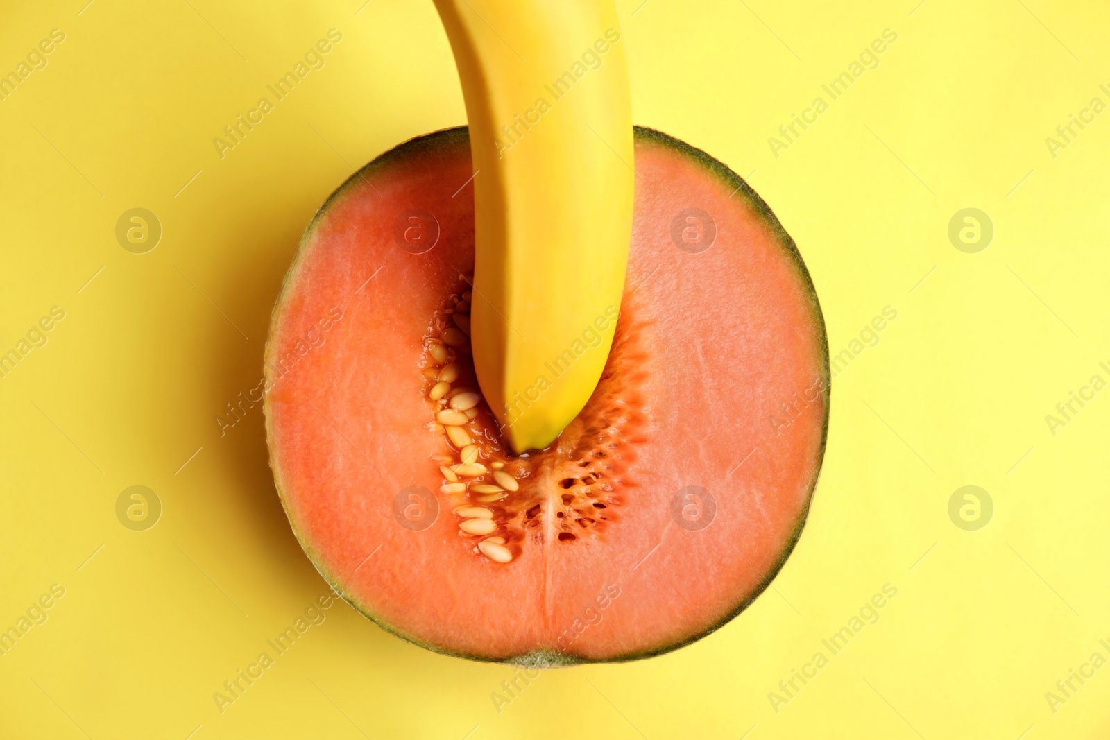 Photo of Flat lay composition with fresh banana and melon on yellow background. Sex concept