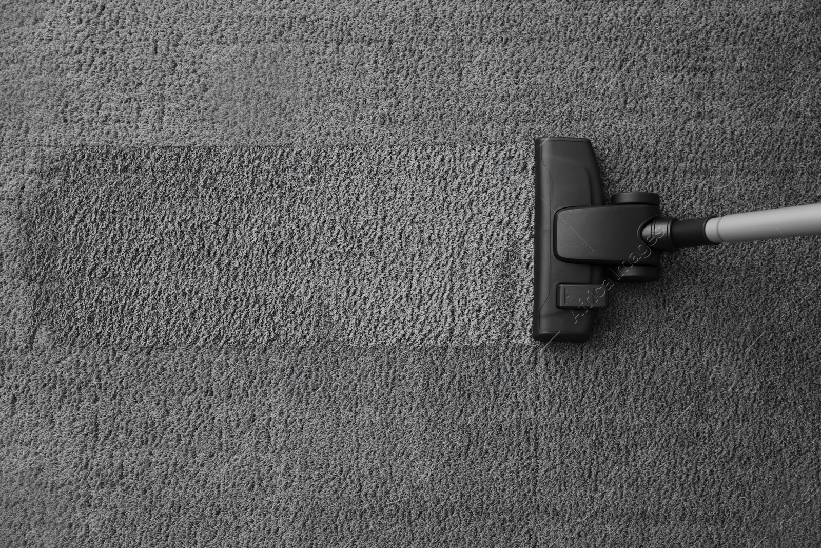 Photo of Modern vacuum cleaner on carpet, top view. Space for text