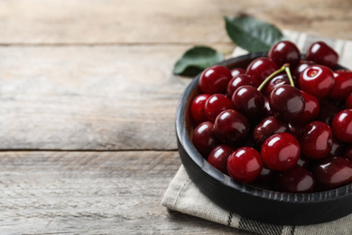 Photo of Sweet juicy cherries on wooden table, closeup. Space for text
