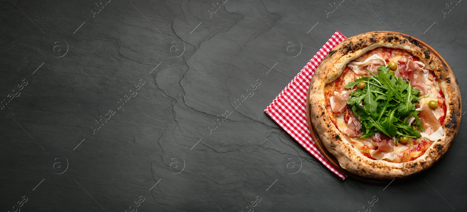 Image of Top view of tasty pizza with meat and arugula on black table, space for text. Banner design
