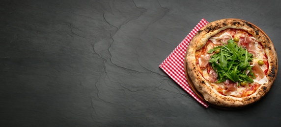 Top view of tasty pizza with meat and arugula on black table, space for text. Banner design