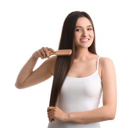 Beautiful young woman with hair brush on white background