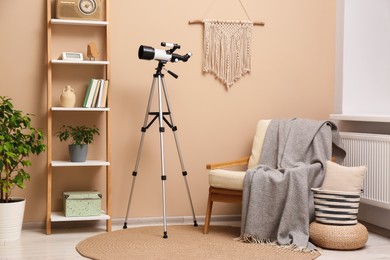 Tripod with modern telescope in stylish room