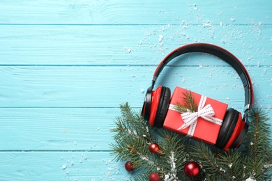 Photo of Flat lay composition with headphones on blue wooden background, space for text. Christmas music concept