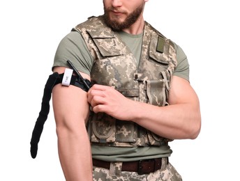 Soldier in military uniform applying medical tourniquet on arm against white background, closeup