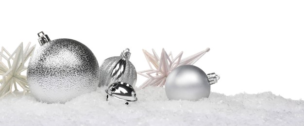 Photo of Beautiful silver Christmas balls and decorative snowflakes on snow against white background