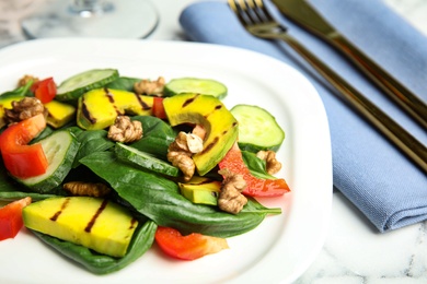 Photo of Delicious avocado salad served on marble table, closeup