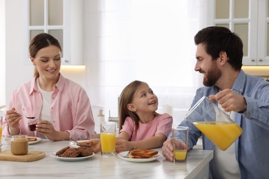 Happy family having breakfast at table in kitchen